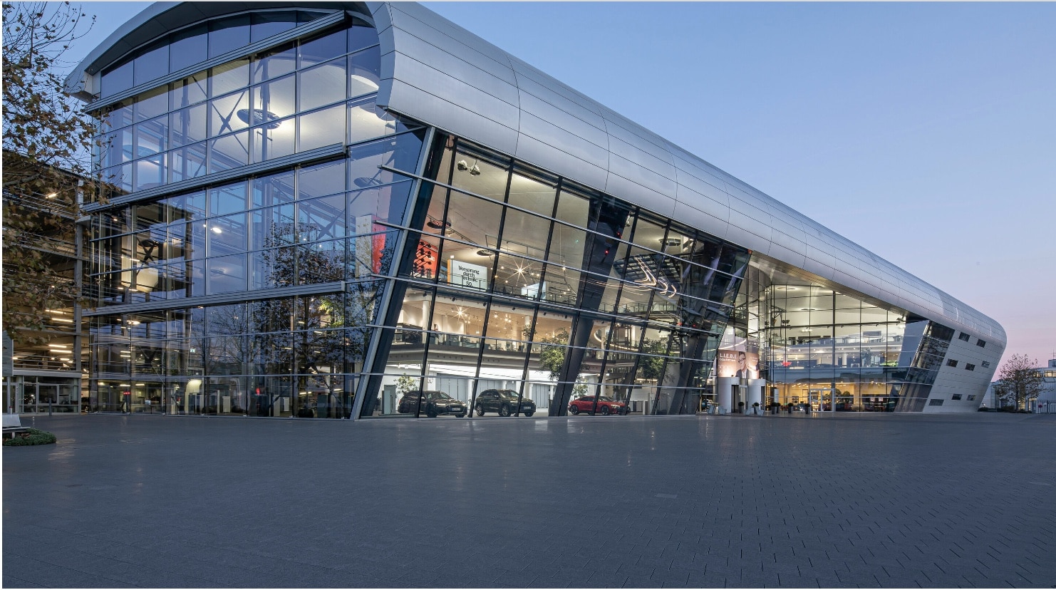 Das Bild zeigtr das Audi Forum in Neckarsulm Ein Gebäude mit großer Glasfront