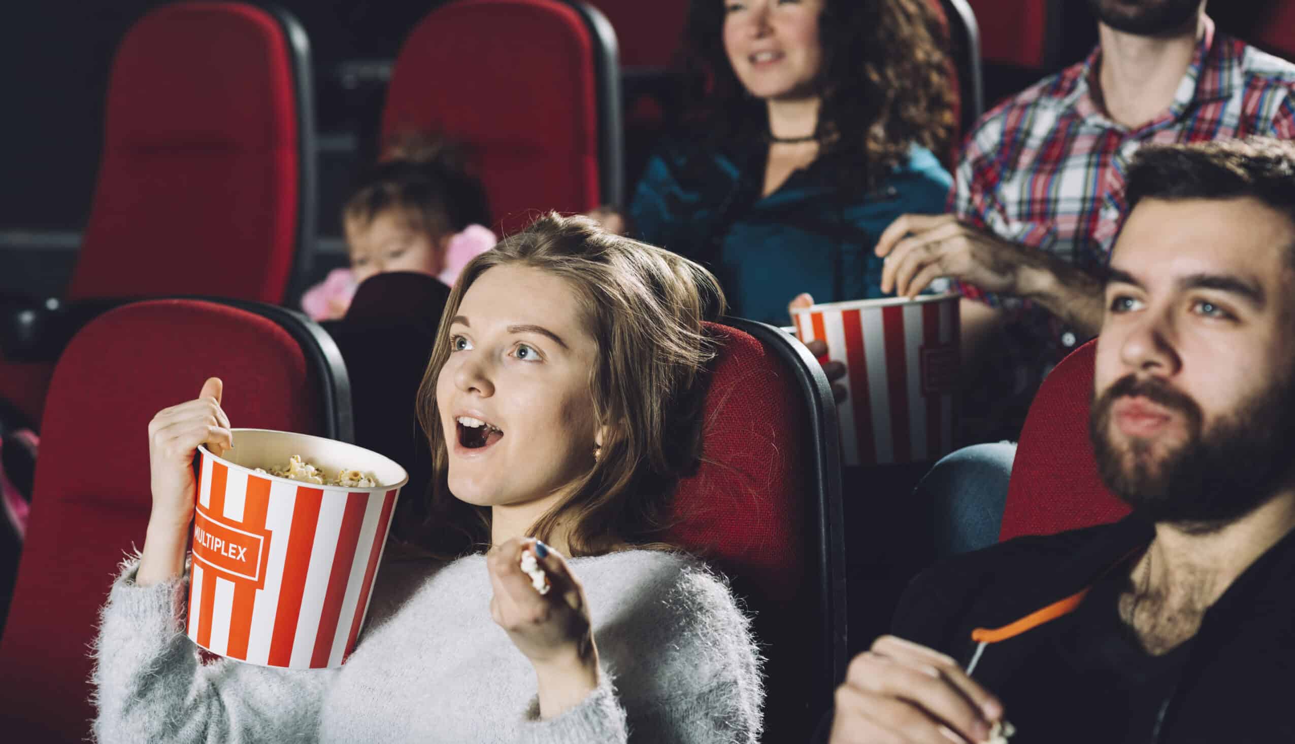 Kinobesucher eine Frau ein Mann die Frau hat einen popcornbecher in der Hand